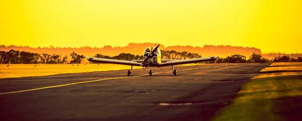 Pequeno avião pousando ao pôr do sol — Fotografia de Stock