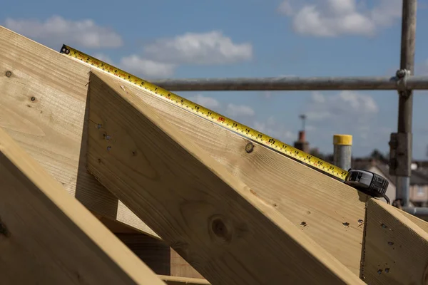 Fragmento de una nueva casa de construcción de techo enmarcado contra un cielo azul —  Fotos de Stock