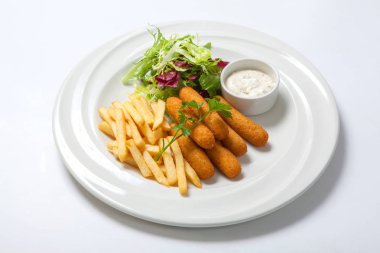 Kızarmış balık sosu, patates kızartması ve taze salata marul beyaz bir plaka üzerinde