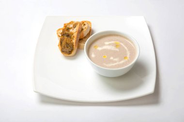 Derin beyaz bir tabak içinde püre mantar çorbası