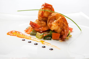 Kızarmış karides üzerinde beyaz bir tabak kızarmış sebze