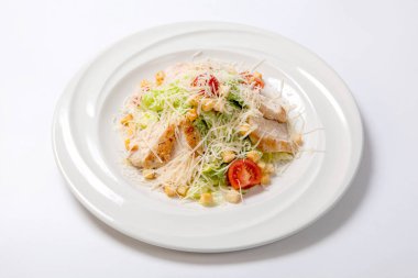 Sezar salatası ile beyaz yuvarlak tabakta tavuk