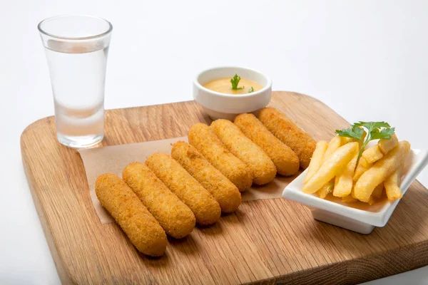 Balık sopalarla bir ahşap tahta üzerine sos ve patates kızartması ile