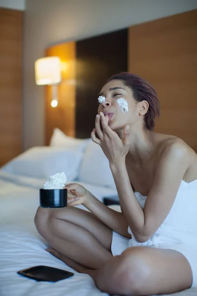 Krásná žena v ručníku na posteli pití kávy se šlehačkou — Stock fotografie