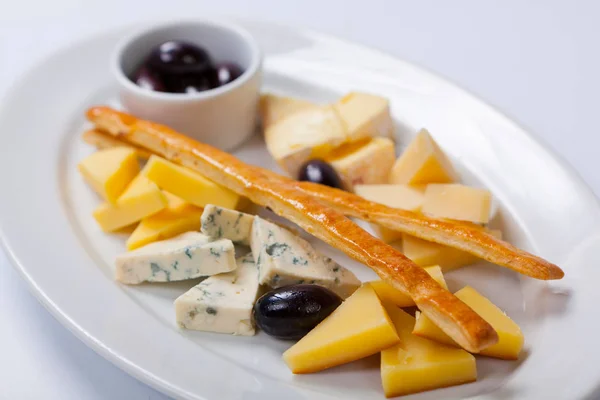 Vari tipi di formaggio su un piatto bianco — Foto Stock