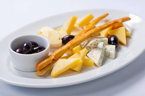 Various types of cheese on a white plate — Stock Photo, Image