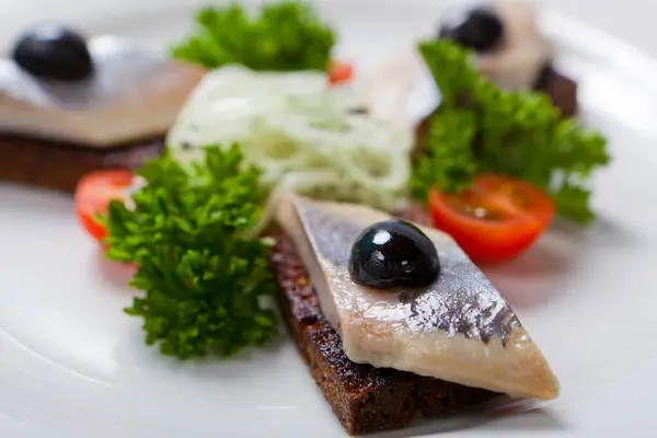 Sliced black bread and herring on a white plate — Stock Photo, Image