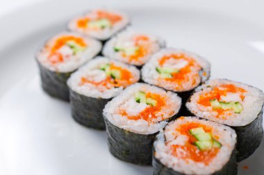 Sake avokado maki sushi beyaz bir plaka üzerinde