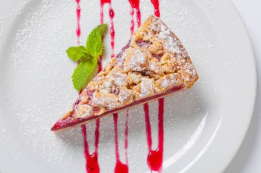 Kiraz kek çatal ile beyaz plaka üzerinde yeşil nane ile. Vişneli tart