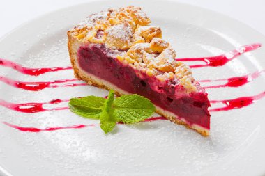 Kiraz kek çatal ile beyaz plaka üzerinde yeşil nane ile. Vişneli tart