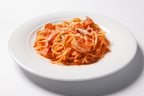 Deliciosos espaguetis de pasta con camarones, salsa de tomate, queso en un plato blanco —  Fotos de Stock