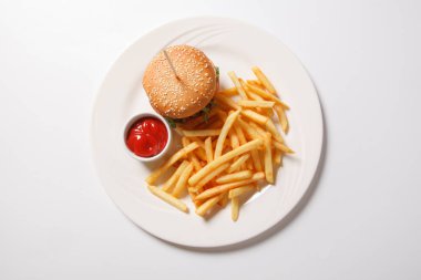 Fast food hamburger ve kızarmış patates beyaz bir plaka üzerinde