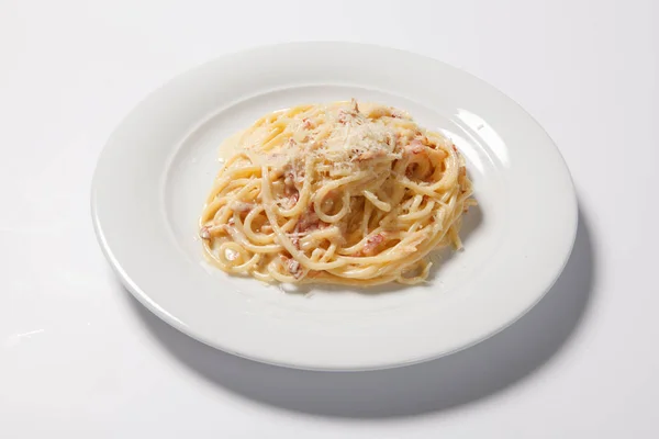 Espaguetis Carbonara con tocino y queso en un plato blanco — Foto de Stock