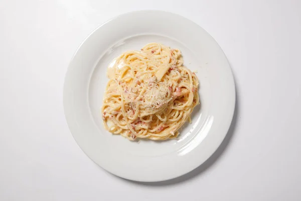 Espaguetis Carbonara con tocino y queso en un plato blanco — Foto de Stock