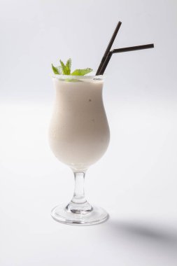 Beyaz bir arka plan üstüne nane yaprağı ile lezzetli muzlu süt