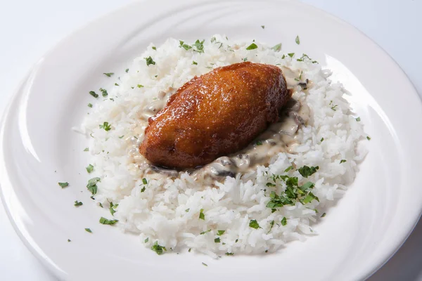 Cordon bleu pirinç beyaz bir plaka üzerinde