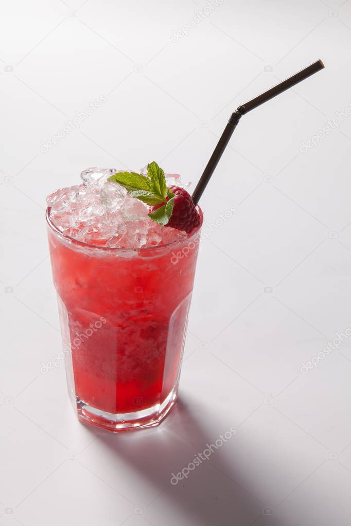 Cold straw red drink with berry and mint leaf.