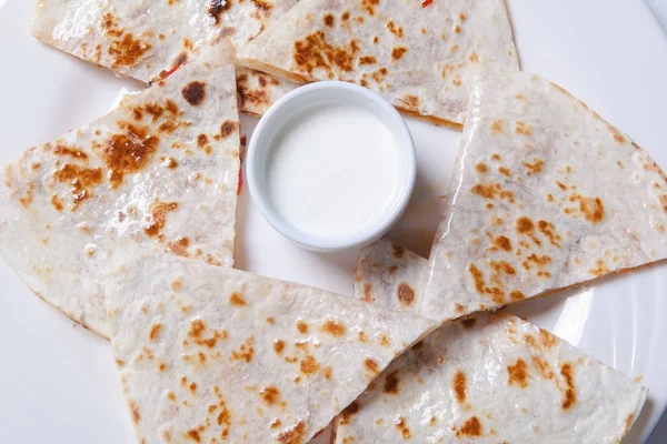 Quesadilla com carne de vaca e frango em uma chapa branca. quesadilla e molho . — Fotografia de Stock