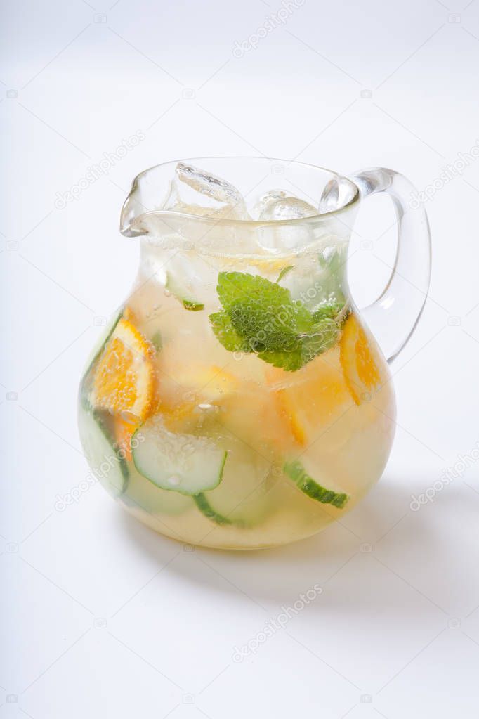 Jug with orange cucumber refreshing drink, rustic style, selective focus