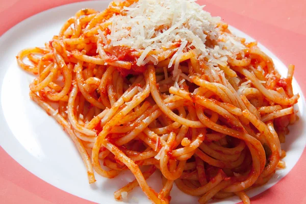 Domates soslu lezzetli makarna spagetti, peynir beyaz bir plaka üzerinde — Stok fotoğraf