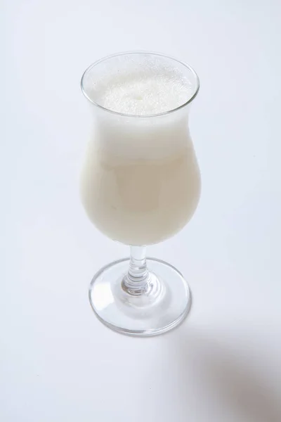 Delicioso milkshake com uma folha de hortelã no topo em um fundo branco — Fotografia de Stock