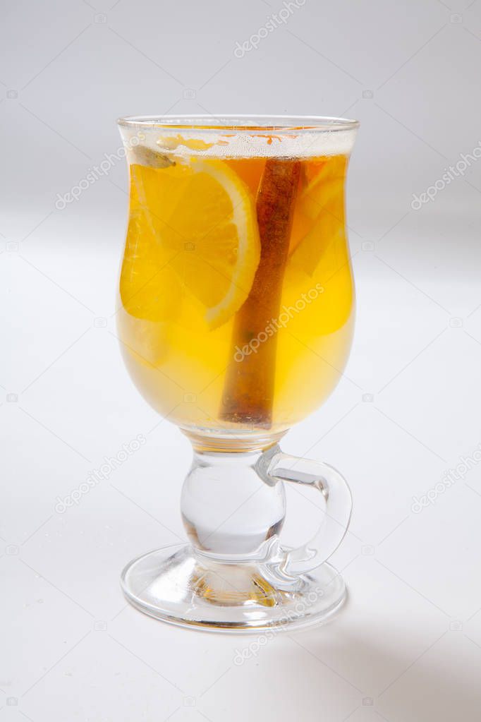 White mulled wine with spices, apple and orange on white background