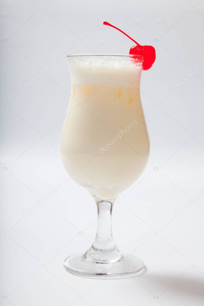 milk cocktail with a cherry in a tall glass