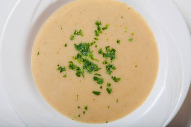 Beyaz bir kase taze otlar ile kremalı sebze çorbası