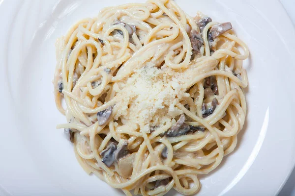 Italienische Pasta mit Pilzen auf weißem Teller — Stockfoto