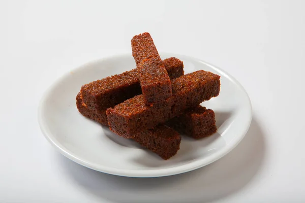 Kavrulmuş sarımsaklı kruton, siyah ekmek beyaz bir plaka üzerinde.