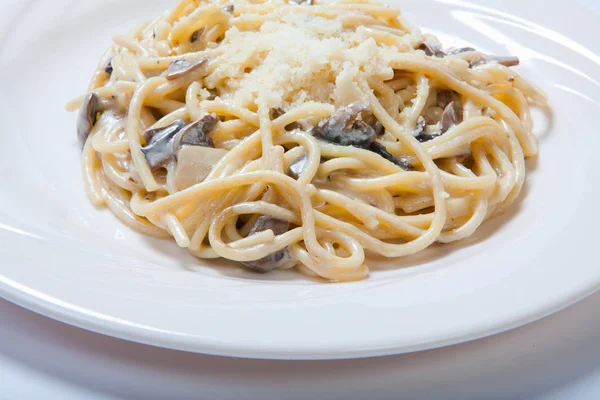 Italienische Pasta mit Pilzen auf weißem Teller — Stockfoto