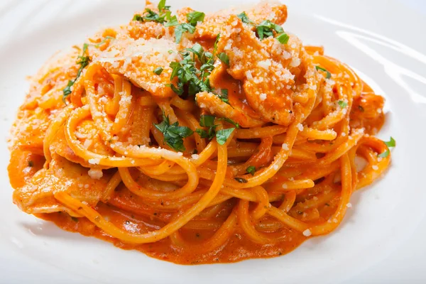 Spaghetti al pollo, cotti in salsa piccante da pomodori, cipolla e aglio . — Foto Stock