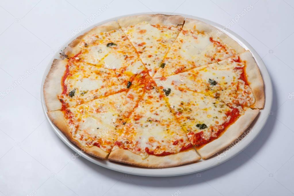 Italian delicious pizza with cheese on a white plate