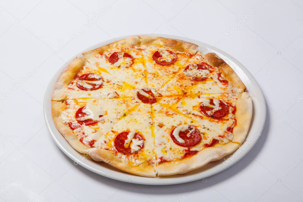 Tasty pizza with salami on white plate. White background