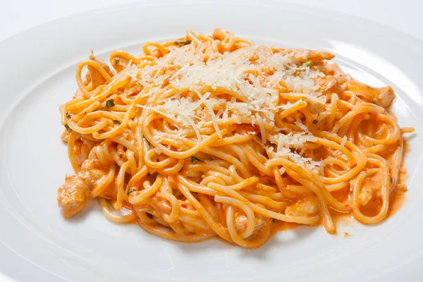 Spaghetti al pollo, cotti in salsa piccante da pomodori, cipolla e aglio . — Foto Stock