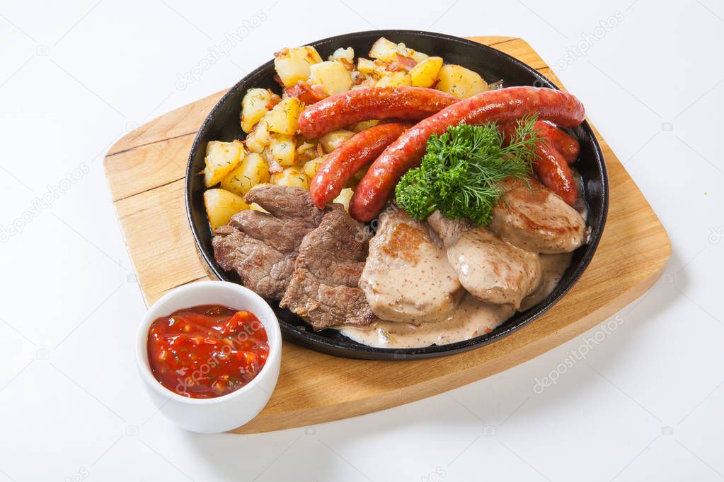 grilled sausages with potatoes, and roasted meat on a grill pan