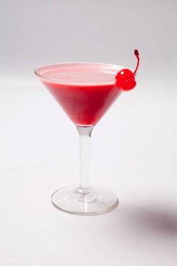Marachino kiraz ile süslenmiş martini cam, kırmızı içecek. Beyaz arka plan üzerinde