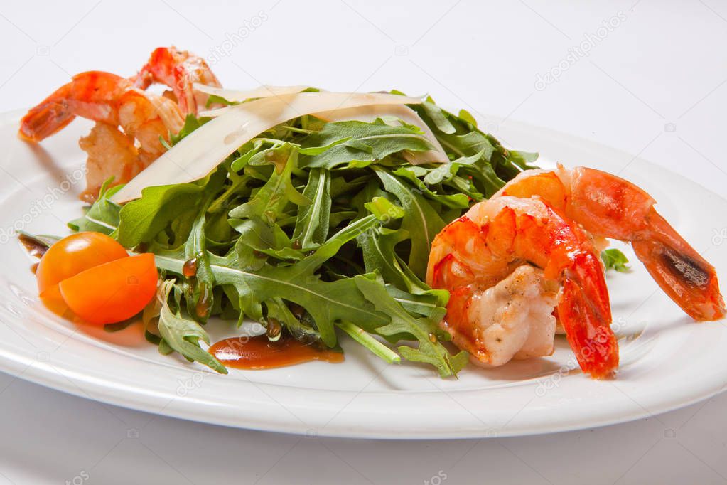 A delicious salad with arugula, cherry tomatoes and shrimps