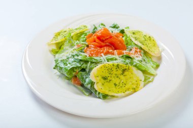 taze Sezar salata somon beyaz plaka üzerinde