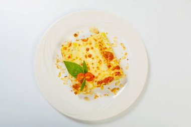 İtalyan lazanya beyaz bir plaka üzerinde rulo