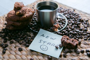 kahve fincanı ve etiket üzerinde mesaj ile çerezleri ve Not Defteri ile ahşap masa üzerinde kahve çekirdekleri