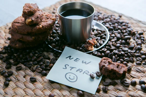 kahve fincanı ve etiket üzerinde mesaj ile çerezleri ve Not Defteri ile ahşap masa üzerinde kahve çekirdekleri