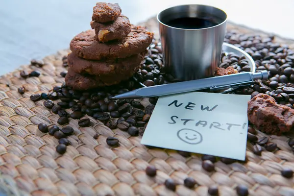 ステッカーにメッセージとクッキーとメモ帳の木製テーブルの上のコーヒー豆とコーヒー カップ — ストック写真