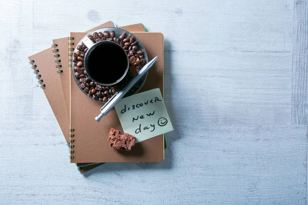 Пустые спиральные блокноты, чашка кофе и ручка на деревянном фоне — стоковое фото