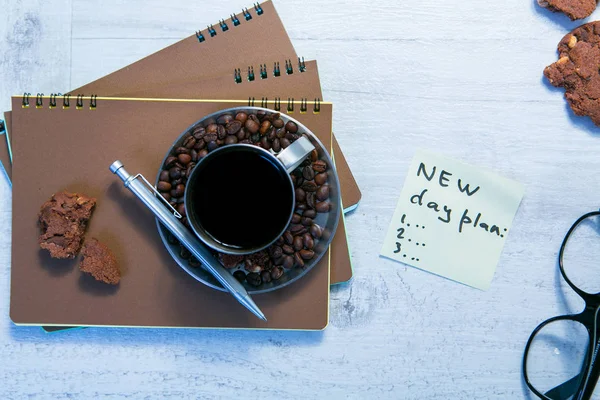 Boş sarmal bloknot, kahve Kupası ve ahşap zemin üzerine kalem