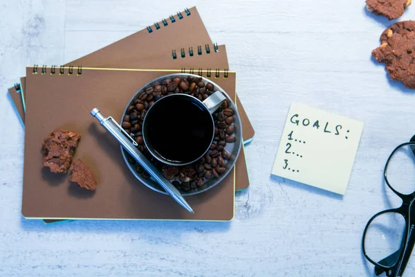 Пустые спиральные блокноты, чашка кофе и ручка на деревянном фоне — стоковое фото