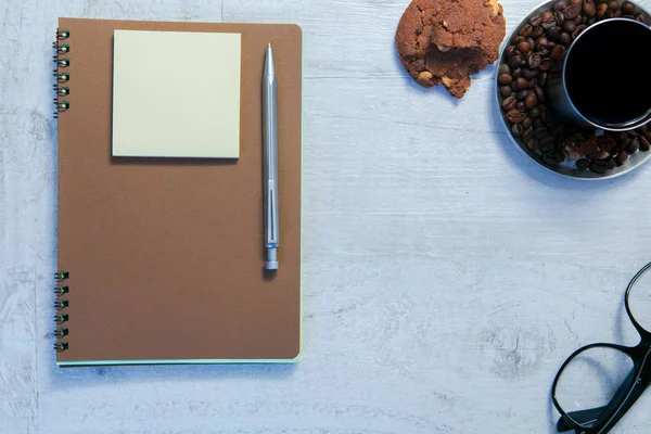 Cuadernos en espiral en blanco, taza de café y lápiz sobre fondo de madera —  Fotos de Stock