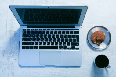 ofis dizüstü bilgisayar, not defteri ve tanımlama bilgisi ile kahve masa üstü görünümüyle çalışma