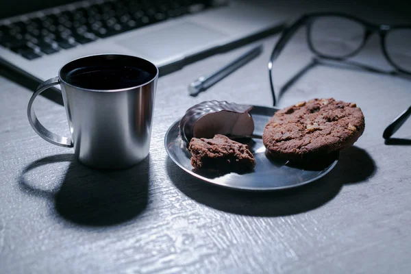 オフィスのワーキング デスク ノート パソコン、ペンとメガネとクッキーお菓子とコーヒー — ストック写真