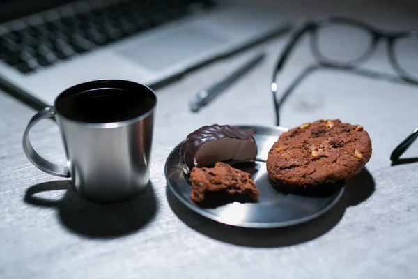 オフィスのワーキング デスク ノート パソコン、ペンとメガネとクッキーお菓子とコーヒー — ストック写真